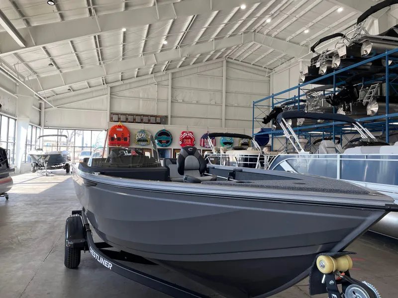 Slide: The Image of 2025 Crestliner 1750 Hawk boat displayed in a spacious showroom with other boats. - 3