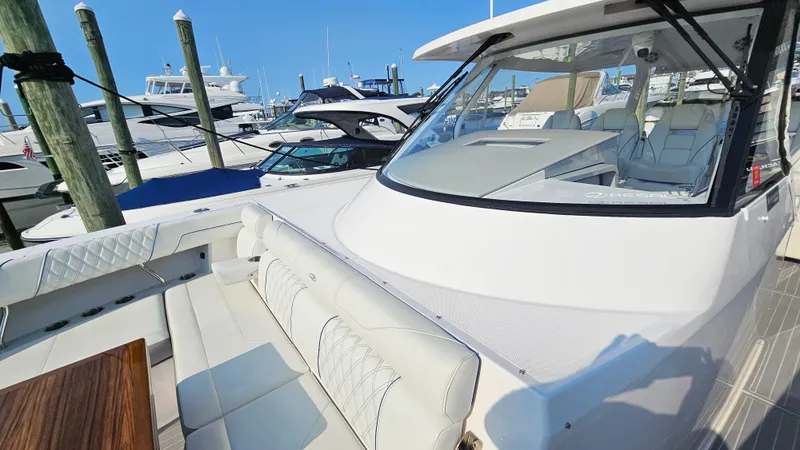 Slide: The Image of 2021 Regal 38 SAV luxury boat docked at marina, featuring spacious seating and sleek design. - 10