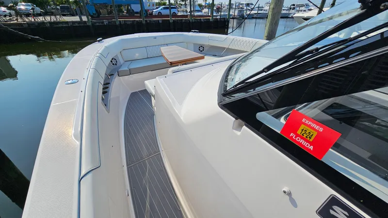 Slide: The Image of 2021 Regal 38 SAV boat docked, featuring spacious deck and seating area. - 11