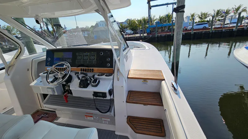 Slide: The Image of 2021 Regal 38 SAV boat helm with modern controls and waterfront view. - 15