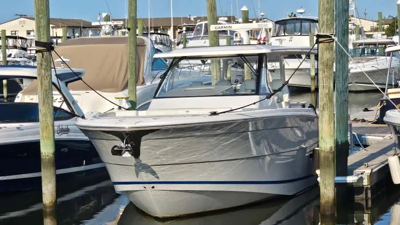 Slide: The Image of 2021 Regal 38 SAV boat docked in a marina, surrounded by other vessels. - 3