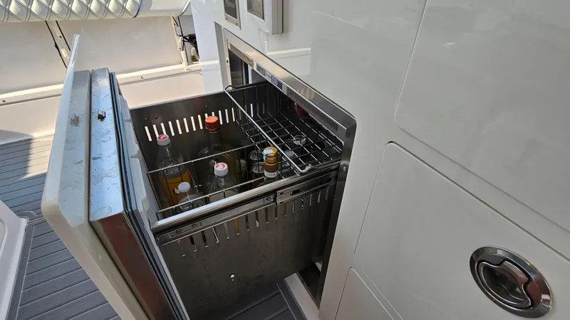 Slide: The Image of Open beverage cooler on 2021 Regal 38 SAV boat, showcasing interior storage. - 37