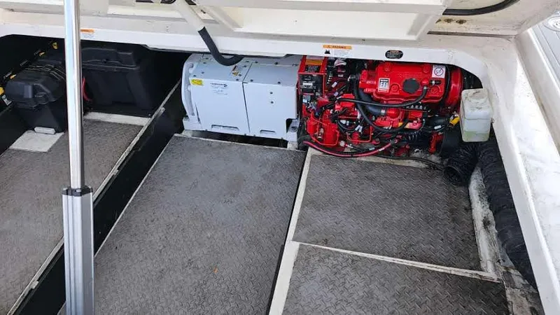 Slide: The Image of Engine compartment of a 2021 Regal 38 SAV boat, featuring a red engine and storage areas. - 45