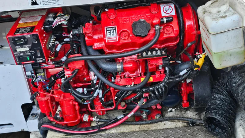 Slide: The Image of Red engine of a 2021 Regal 38 SAV boat, showcasing intricate components and wiring. - 46