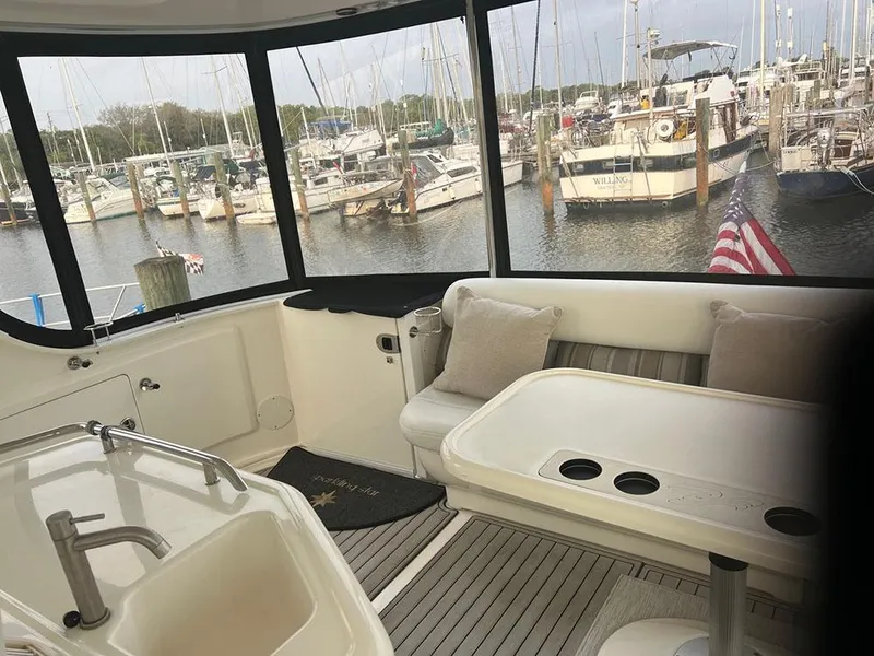 Slide: The Image of 2003 Sea Ray 390 Motor Yacht interior with marina view, featuring seating and table. - 19