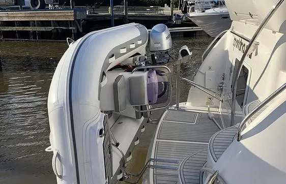 Slide: The Image of 2003 Sea Ray 390 Motor Yacht with attached dinghy at marina. - 2