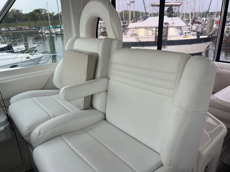 Slide: The Image of 2003 Sea Ray 390 Motor Yacht interior with white leather seating at marina. - 23