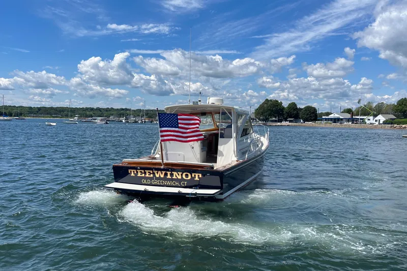 Slide: The Image of 2002 Little Harbor WhisperJet boat cruising on a sunny day with American flag. - 18