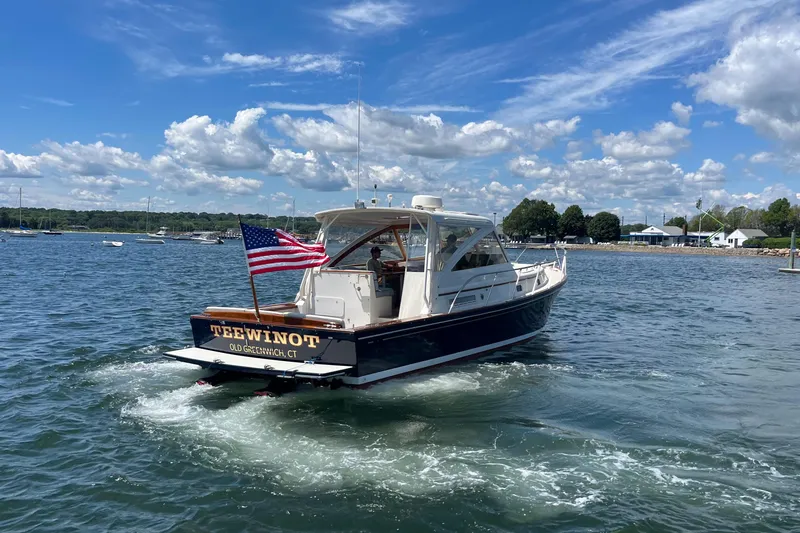 Slide: The Image of 2002 Little Harbor WhisperJet boat cruising on a sunny day with American flag. - 19