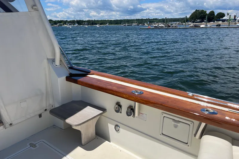 Slide: The Image of 2002 Little Harbor WhisperJet boat interior with wooden trim, overlooking a scenic waterfront. - 22