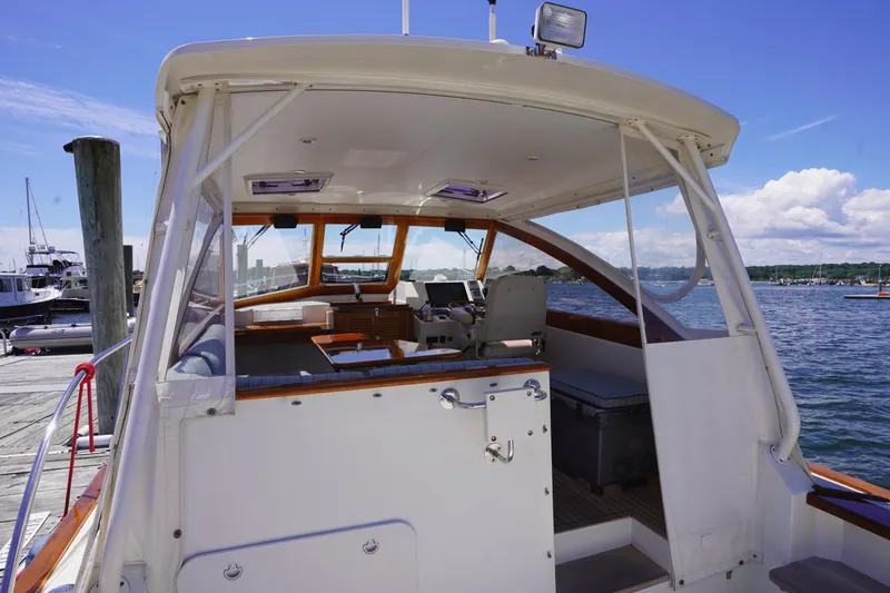 Slide: The Image of 2002 Little Harbor WhisperJet boat interior at dock, featuring helm and seating area. - 23