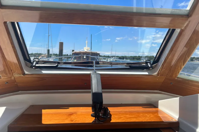 Slide: The Image of Interior view of 2002 Little Harbor WhisperJet boat with wooden accents and marina backdrop. - 36