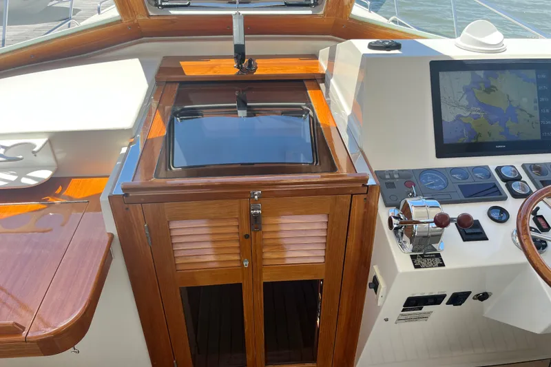 Slide: The Image of 2002 Little Harbor WhisperJet helm with wooden cabinetry and navigation controls. - 38