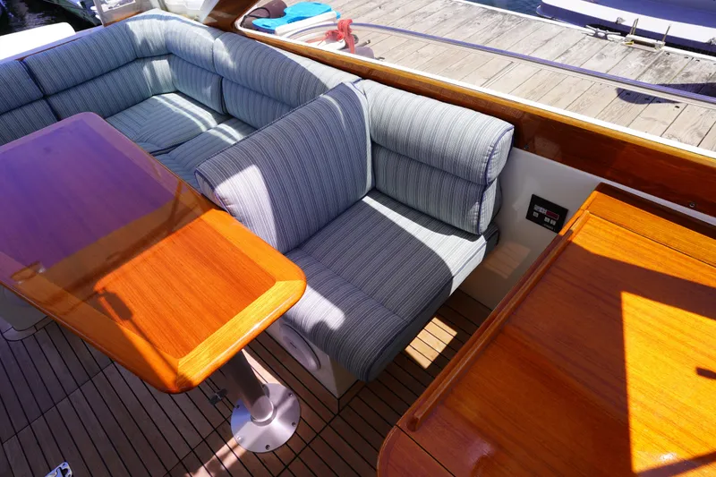 Slide: The Image of 2002 Little Harbor WhisperJet interior with striped seating and wooden tables on a boat deck. - 46