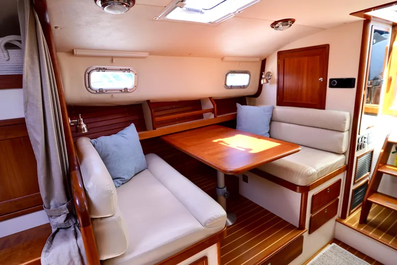 Slide: The Image of Interior of 2002 Little Harbor WhisperJet, featuring cozy seating and wooden table. - 47