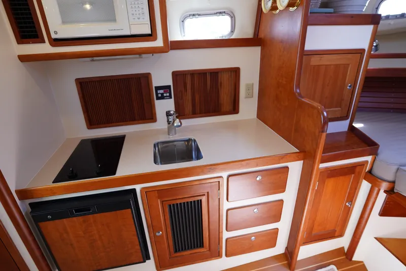 Slide: The Image of 2002 Little Harbor WhisperJet kitchen with wooden cabinetry, sink, stove, and microwave. - 49