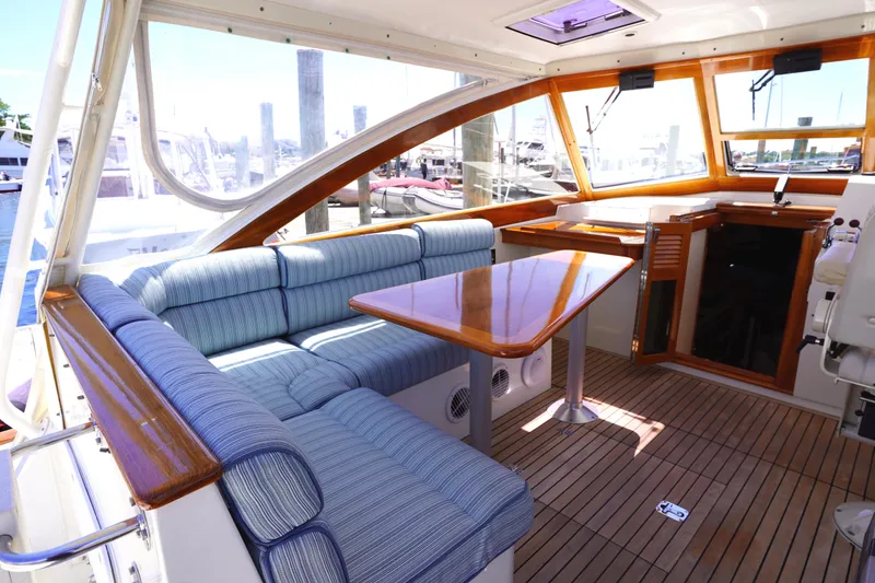 Slide: The Image of 2002 Little Harbor WhisperJet interior with blue seating and wooden table. - 7