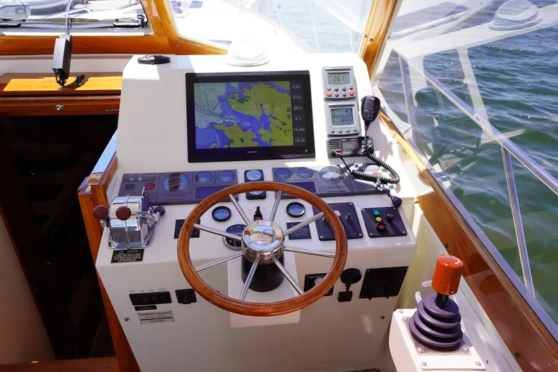 Slide: The Image of Control panel of a 2002 Little Harbor WhisperJet boat with navigation screen and steering wheel. - 8
