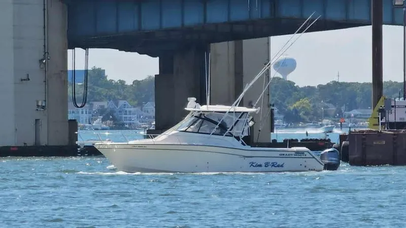 Slide: The Image of 2016 Grady-White Express 330 boat cruising under a bridge on a sunny day. - 0