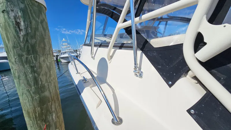 Slide: The Image of 2016 Grady-White Express 330 boat docked, showcasing sleek design and sturdy railings. - 14
