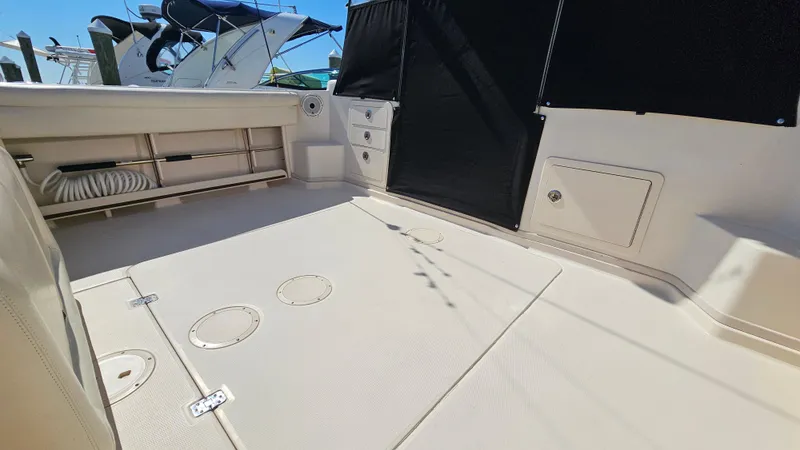 Slide: The Image of 2016 Grady-White Express 330 boat deck with storage compartments and seating area. - 21