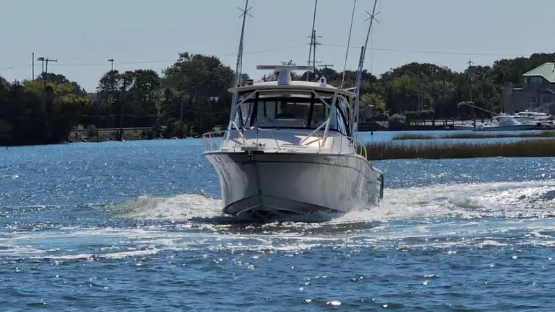 Slide: The Image of 2016 Grady-White Express 330 boat cruising on a sunny day in a scenic waterway. - 4