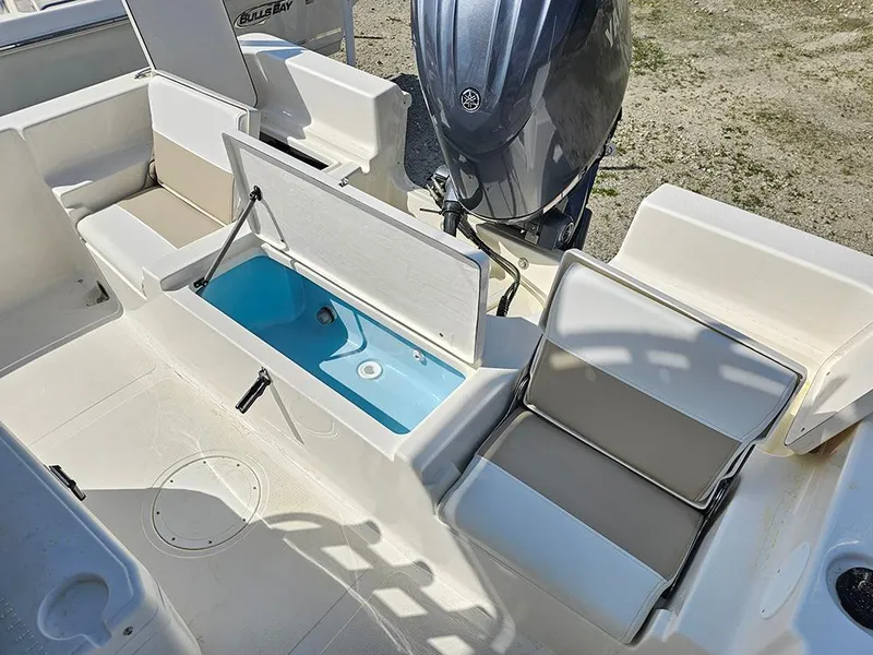 Slide: The Image of 2025 Bulls Bay 2200 XS boat interior with open storage compartments and seating. - 11