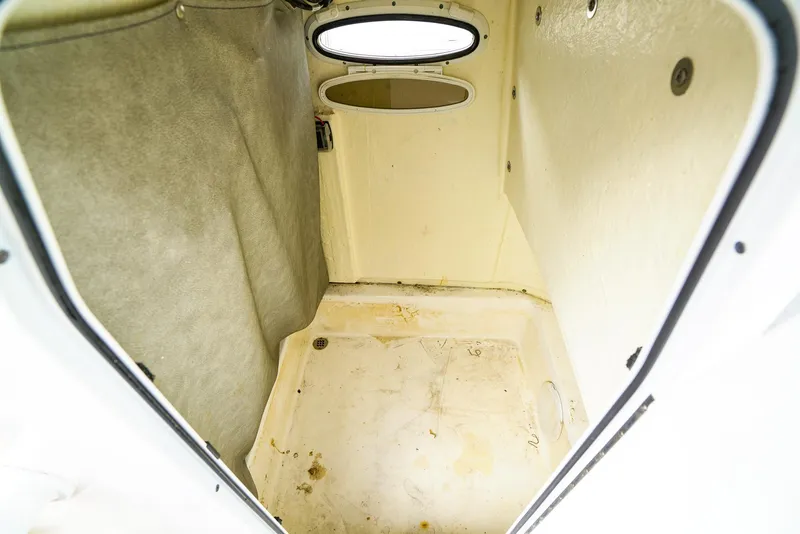 Slide: The Image of 2021 Sea Pro 219 CC interior cabin with oval window and beige walls. - 14