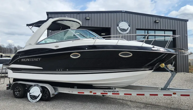 Slide: The Image of 2018 Monterey 275 Sport Yacht on trailer, parked outside a building. - 0