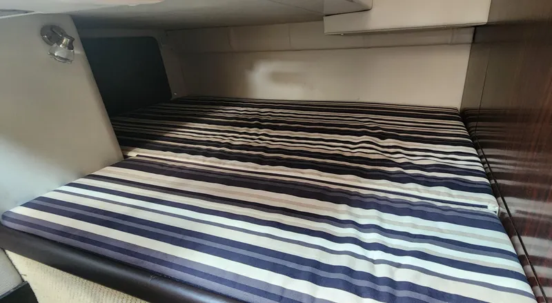 Slide: The Image of 2018 Monterey 275 Sport Yacht cabin with striped bedding. - 13