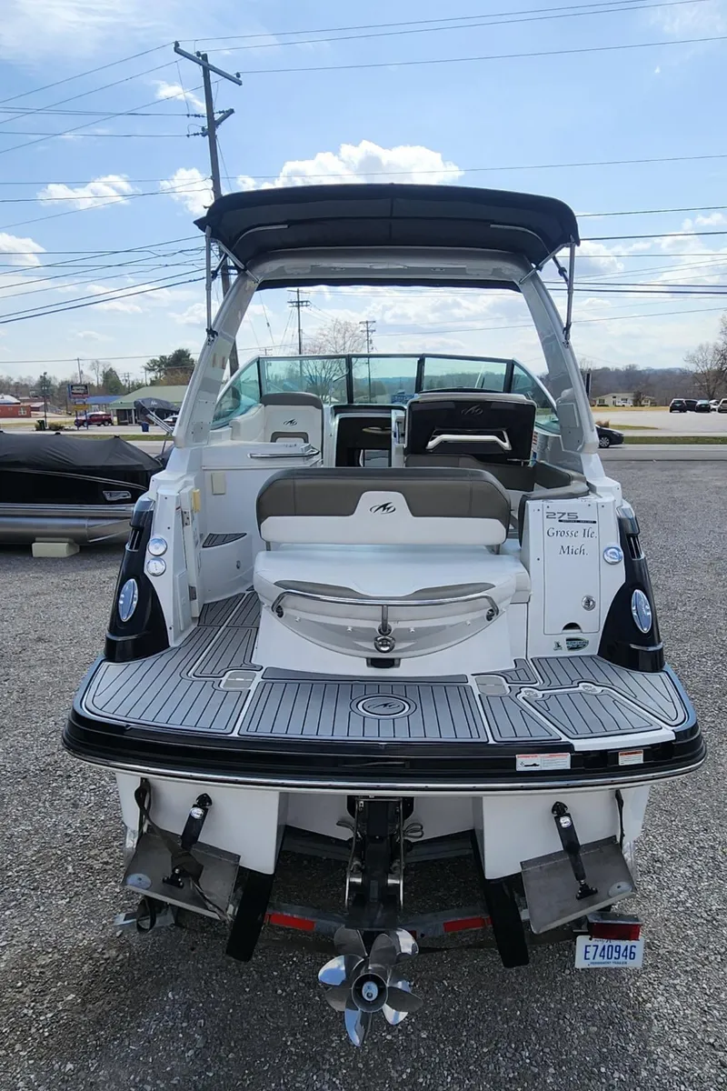 Slide: The Image of 2018 Monterey 275 Sport Yacht, rear view, docked on gravel, clear sky background. - 3