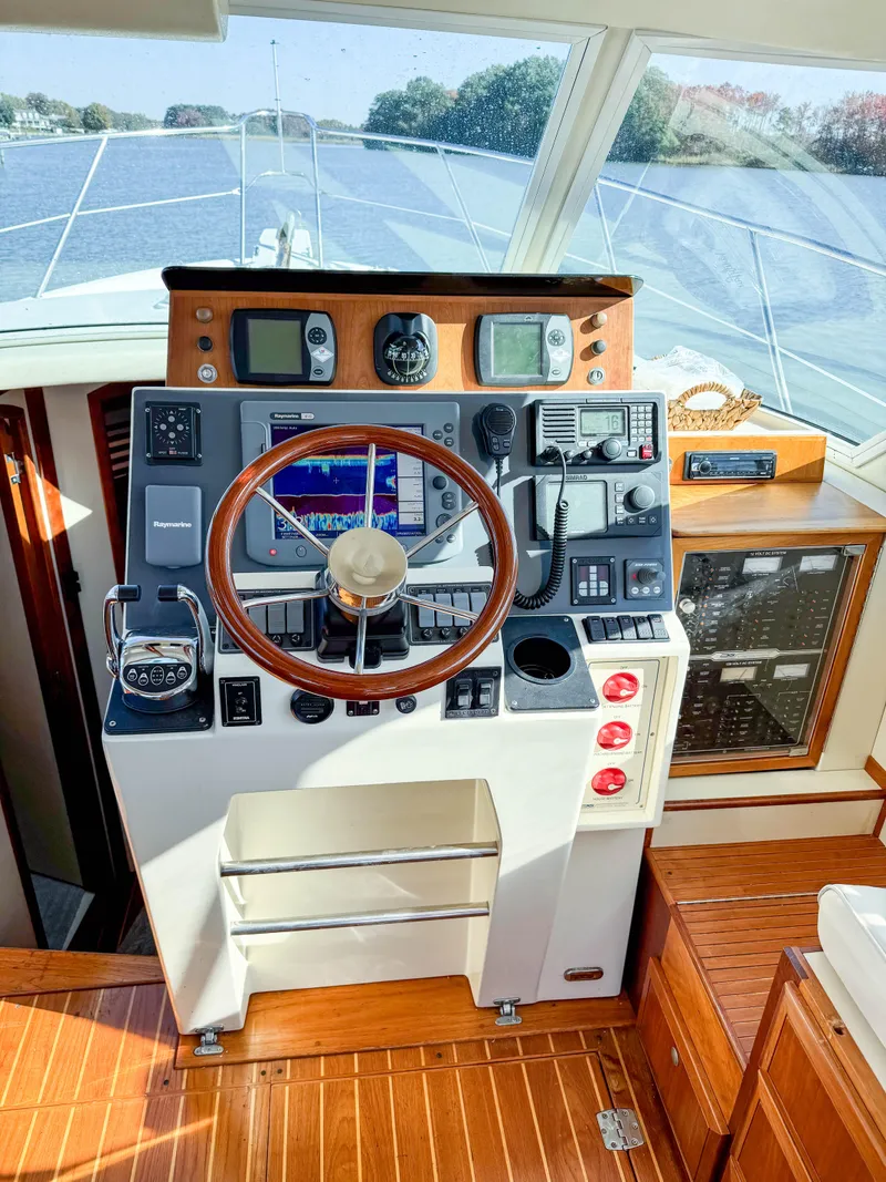 Slide: The Image of 2005 Compton 33 boat helm with wooden steering wheel and navigation instruments. - 4