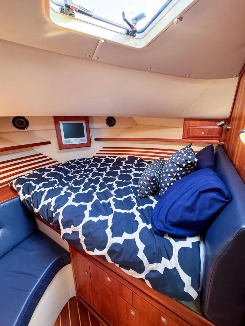 Slide: The Image of Cozy cabin interior of a 2005 Compton 33 boat with patterned bedding and wood accents. - 5