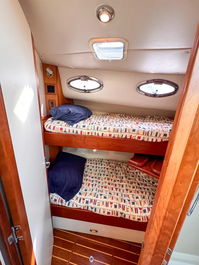 Slide: The Image of Compact cabin with wooden bunk beds in a 2005 Compton 33 boat. - 7
