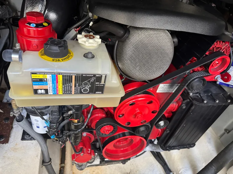 Slide: The Image of Engine compartment of a 2023 Schaefer 375 HT boat, featuring red components and a coolant reservoir. - 42