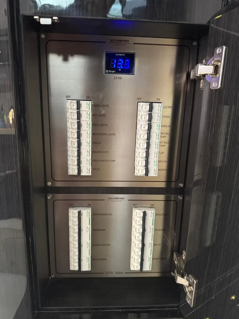 Slide: The Image of Electrical panel inside 2023 Schaefer 375 HT boat, featuring circuit breakers and digital display. - 47