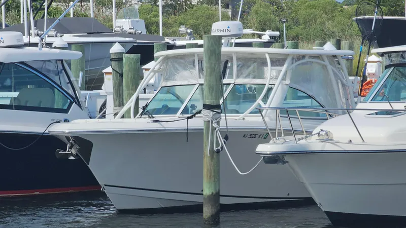 Slide: The Image of 2019 Sailfish 325 DC boat docked at marina, surrounded by other vessels. - 10