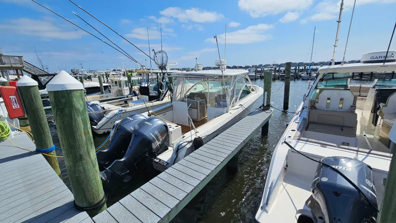 Slide: The Image of 2019 Sailfish 325 DC boat docked at marina under blue sky. - 12