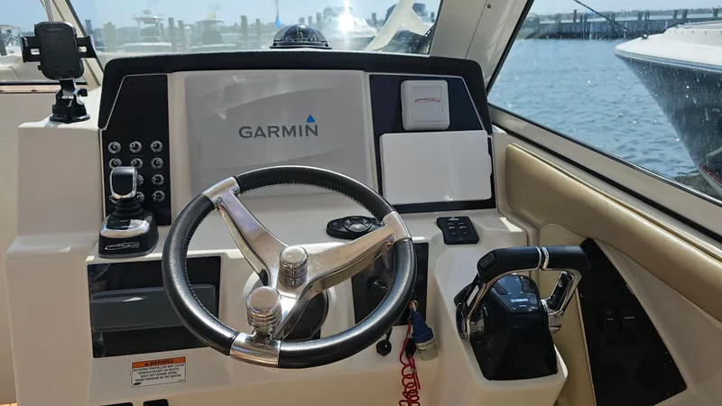 Slide: The Image of 2019 Sailfish 325 DC helm with Garmin navigation system and steering wheel. - 24
