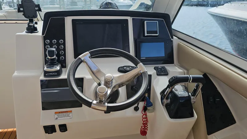 Slide: The Image of 2019 Sailfish 325 DC boat helm with steering wheel and navigation controls. - 25
