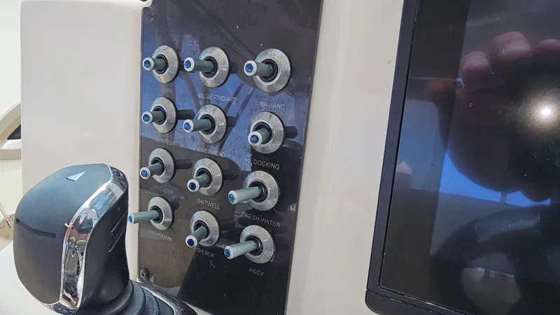 Slide: The Image of Control panel of 2019 Sailfish 325 DC boat with switches and display screen. - 27