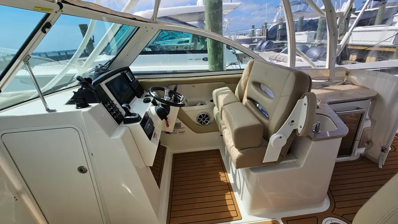 Slide: The Image of 2019 Sailfish 325 DC boat interior with helm, seating, and wood flooring. - 30