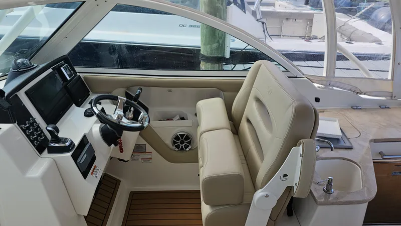 Slide: The Image of 2019 Sailfish 325 DC boat interior with steering wheel and beige seating. - 31