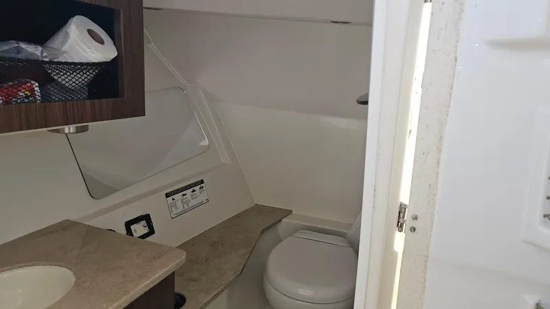 Slide: The Image of 2019 Sailfish 325 DC boat bathroom interior with toilet and sink. - 36