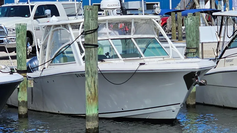 Slide: The Image of 2019 Sailfish 325 DC boat docked at marina, surrounded by pilings. - 4