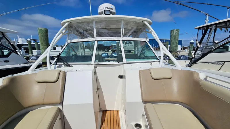 Slide: The Image of 2019 Sailfish 325 DC boat with tan seating and Garmin equipment at a marina. - 40