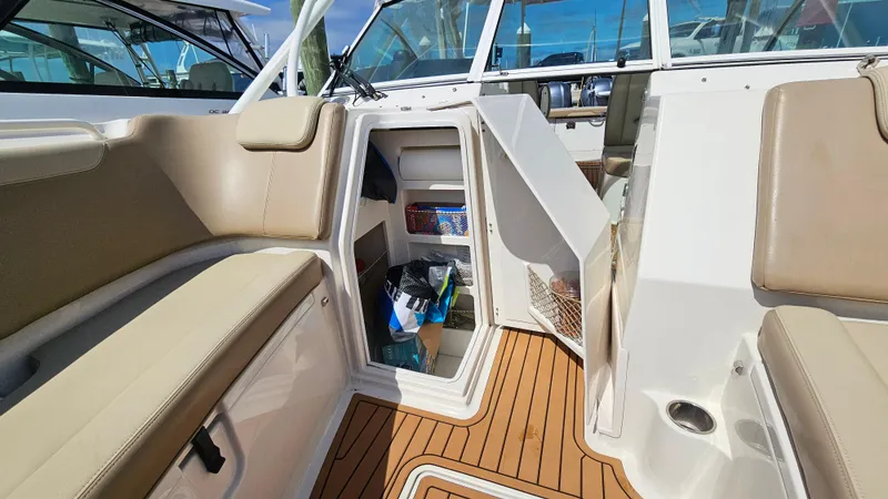 Slide: The Image of 2019 Sailfish 325 DC boat interior with open storage compartment and cushioned seating. - 41