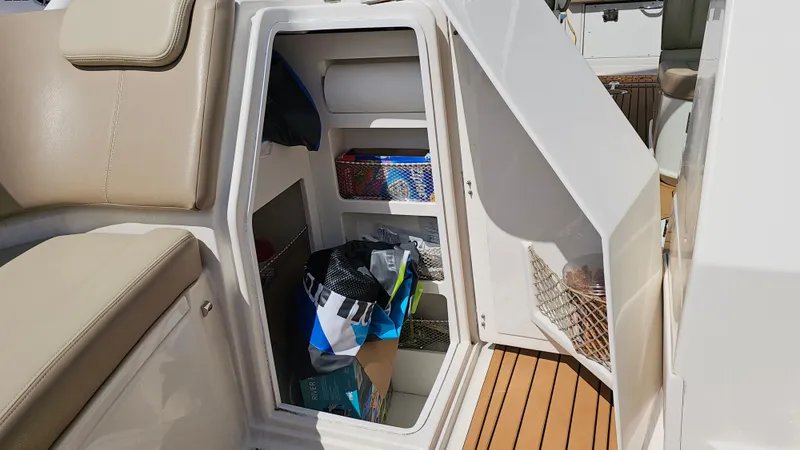 Slide: The Image of Storage compartment on 2019 Sailfish 325 DC boat with organized shelves and items. - 42