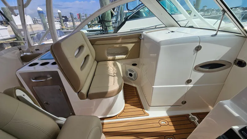 Slide: The Image of 2019 Sailfish 325 DC boat interior with beige seating and wood flooring. - 47