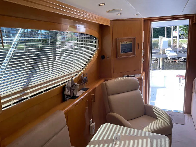Slide: The Image of Interior of 2001 Hatteras 55 Convertible yacht with plush seating and wooden accents. - 13